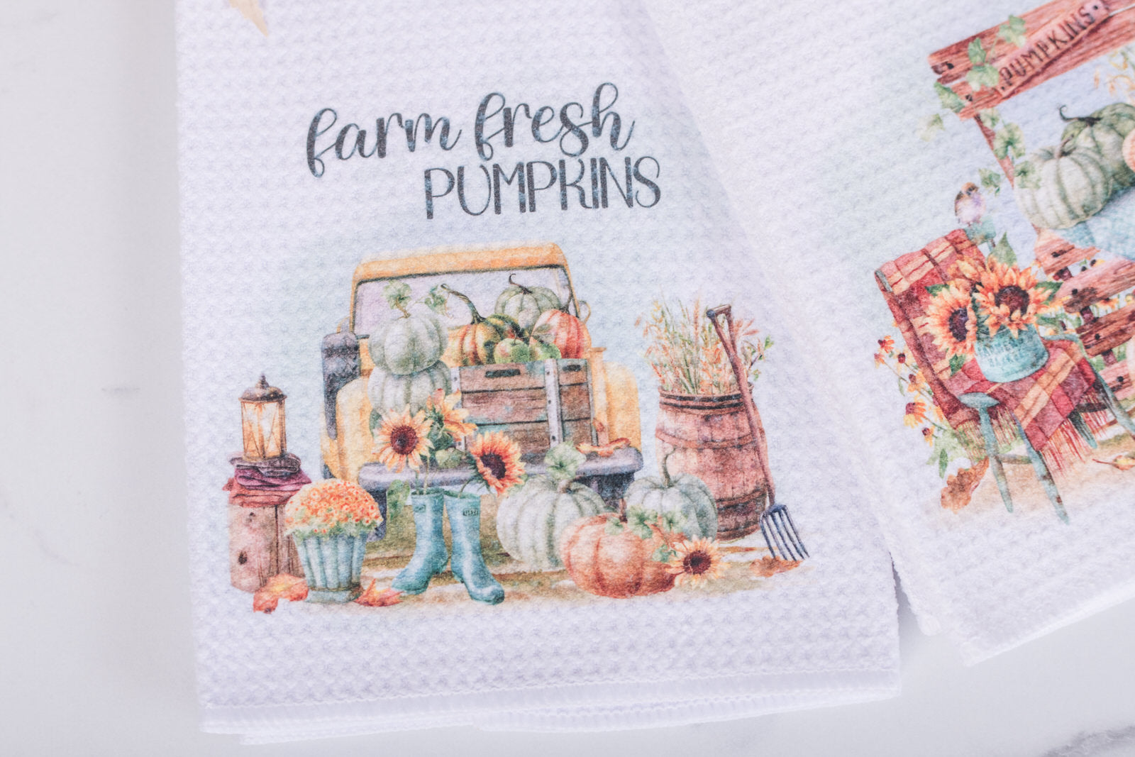 Decorative kitchen towel with 'Farm Fresh Pumpkins' text and autumn-themed design.