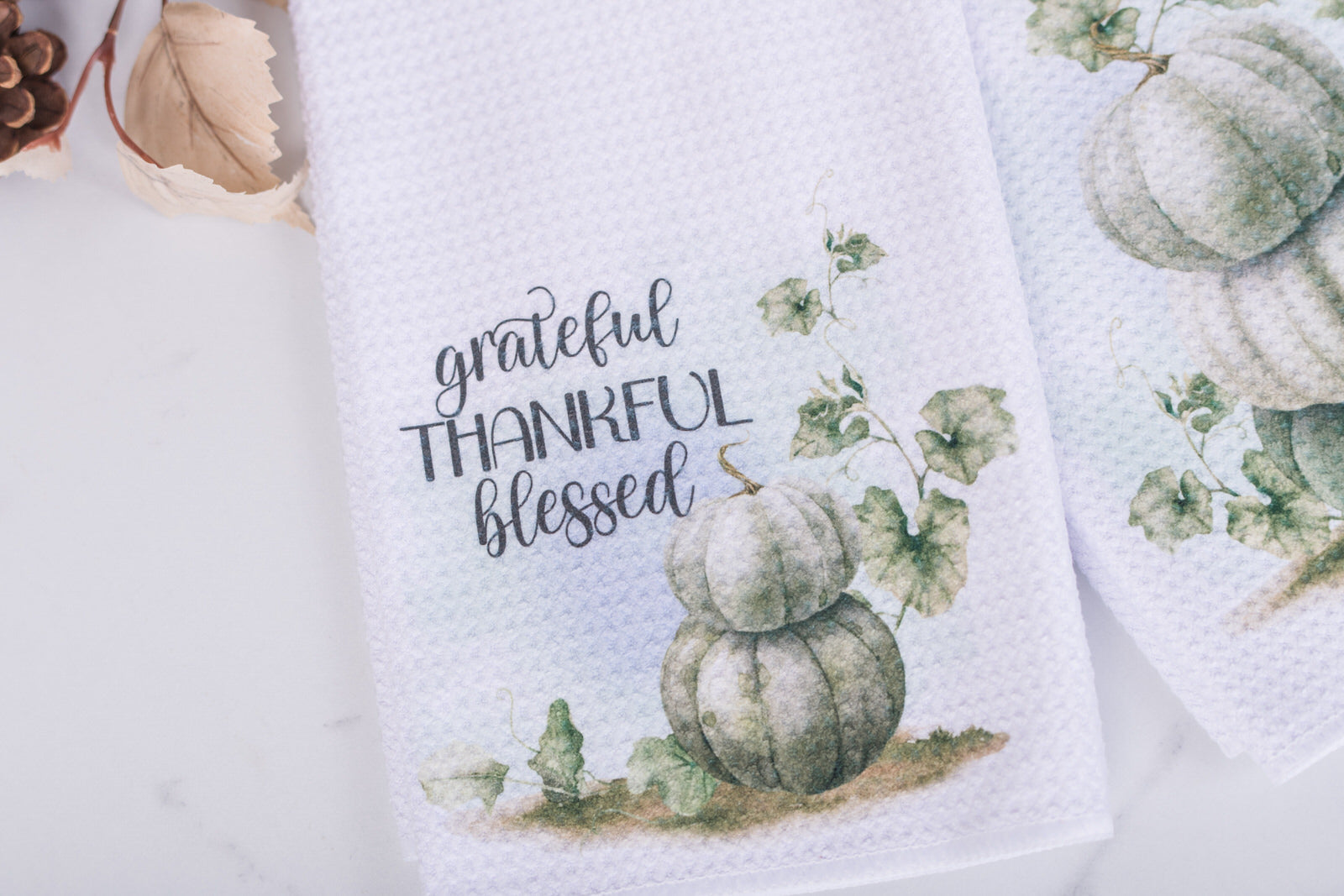 Towel with 'grateful thankful blessed' text and pumpkin design on a white background