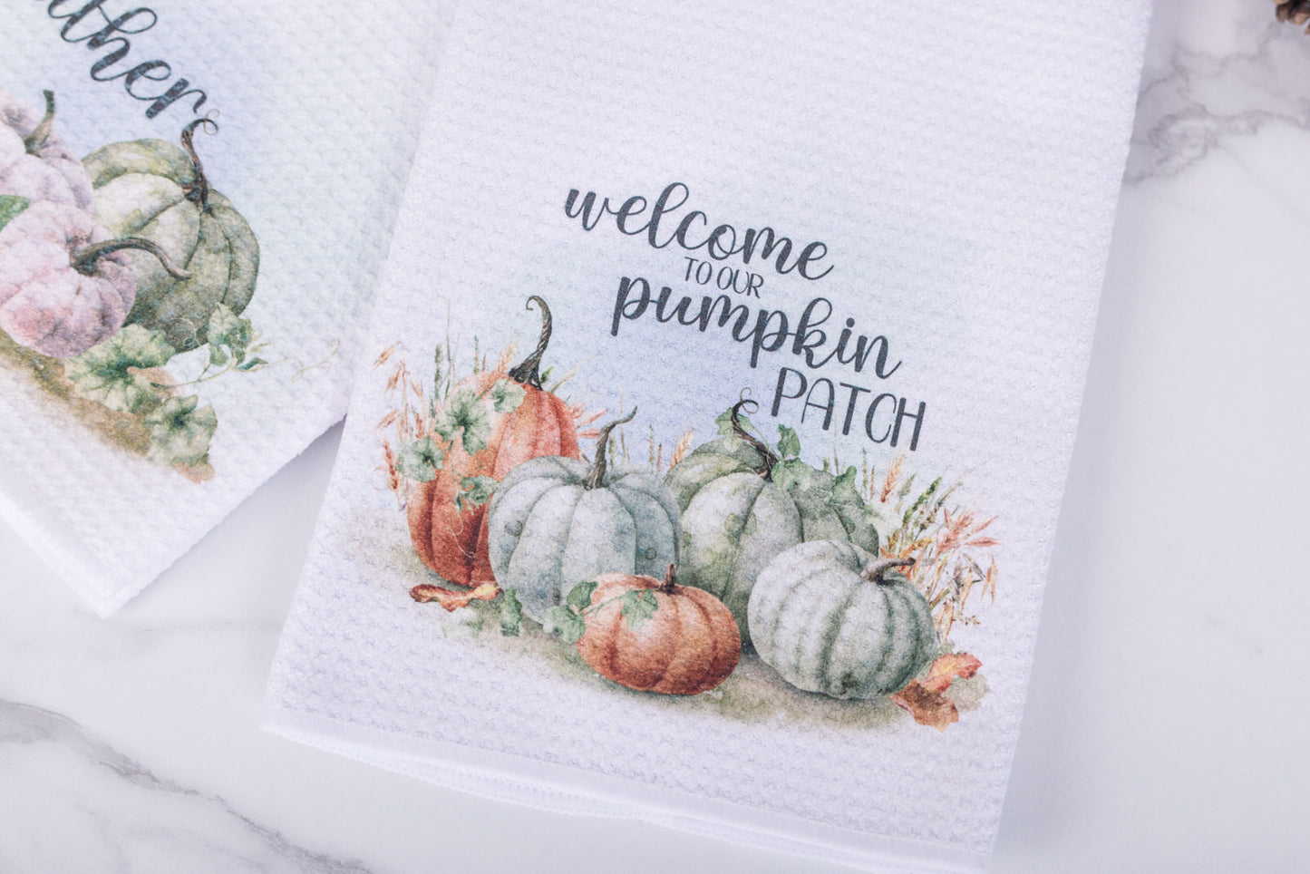 White tea towel with “Welcome to Our Pumpkin Patch” text and watercolor pumpkins in rustic tones