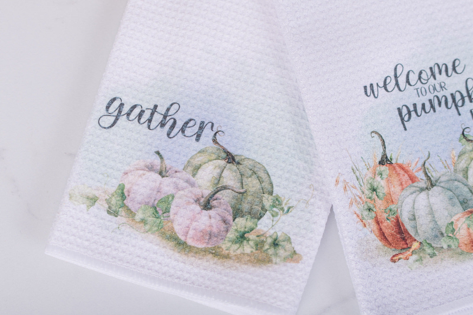 White tea towel with “Gather” text and watercolor pumpkins in green and  white