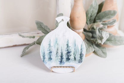 Ceramic spoon rest with watercolor pine trees and forest background