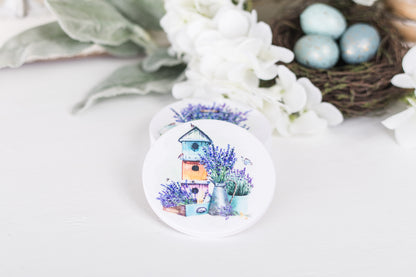 A set of four white ceramic coasters with a floral design and a French lavender theme, featuring a house and lavender bushes.
