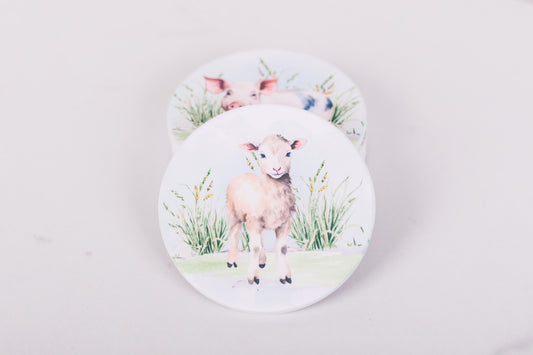 Two coasters with illustrations of lambs on a light gray background