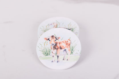 Homestead Collection coasters with cow illustrations on a light gray background