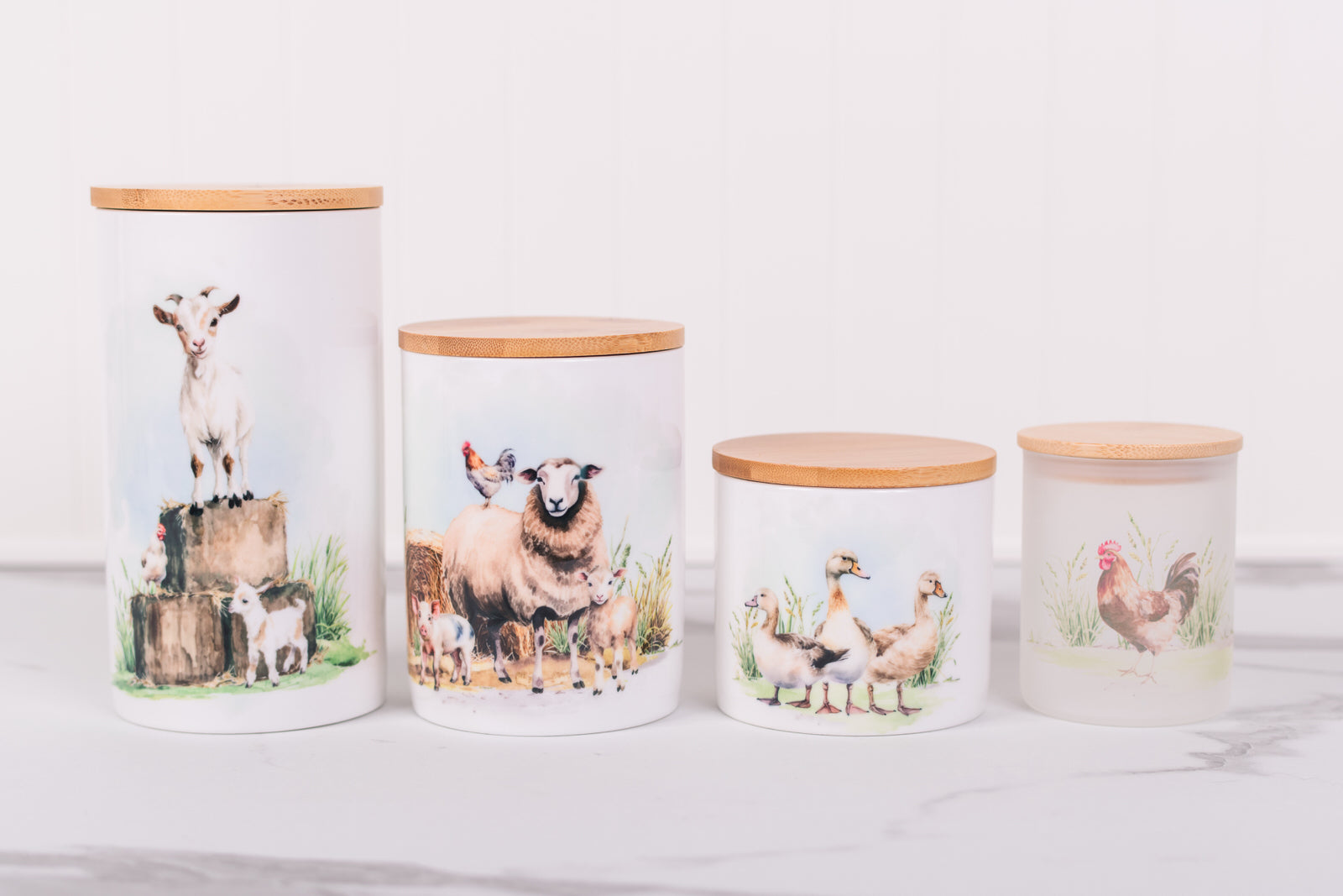 Four ceramic jars with farm animal-themed designs on a white surface