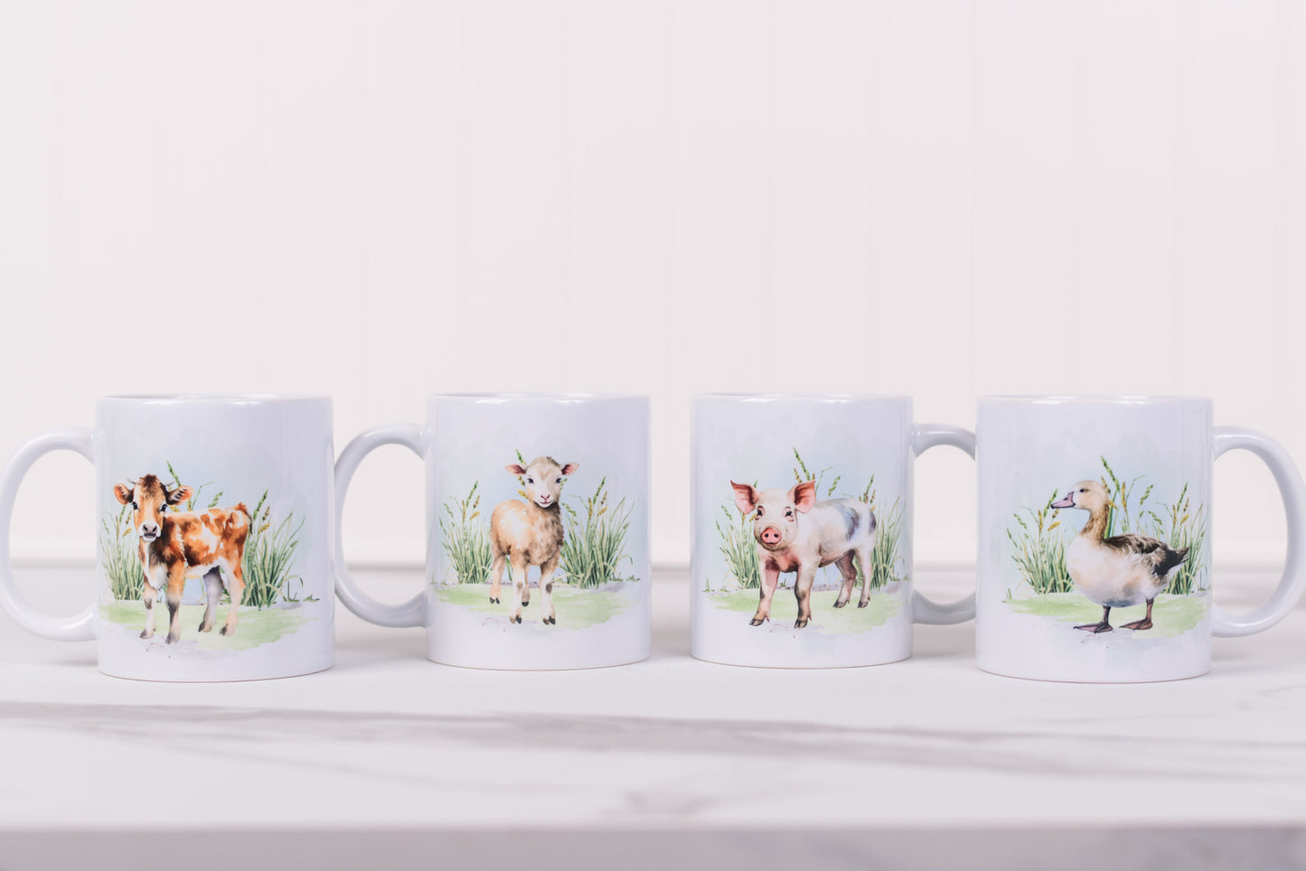 Four mugs with animal illustrations on a white surface