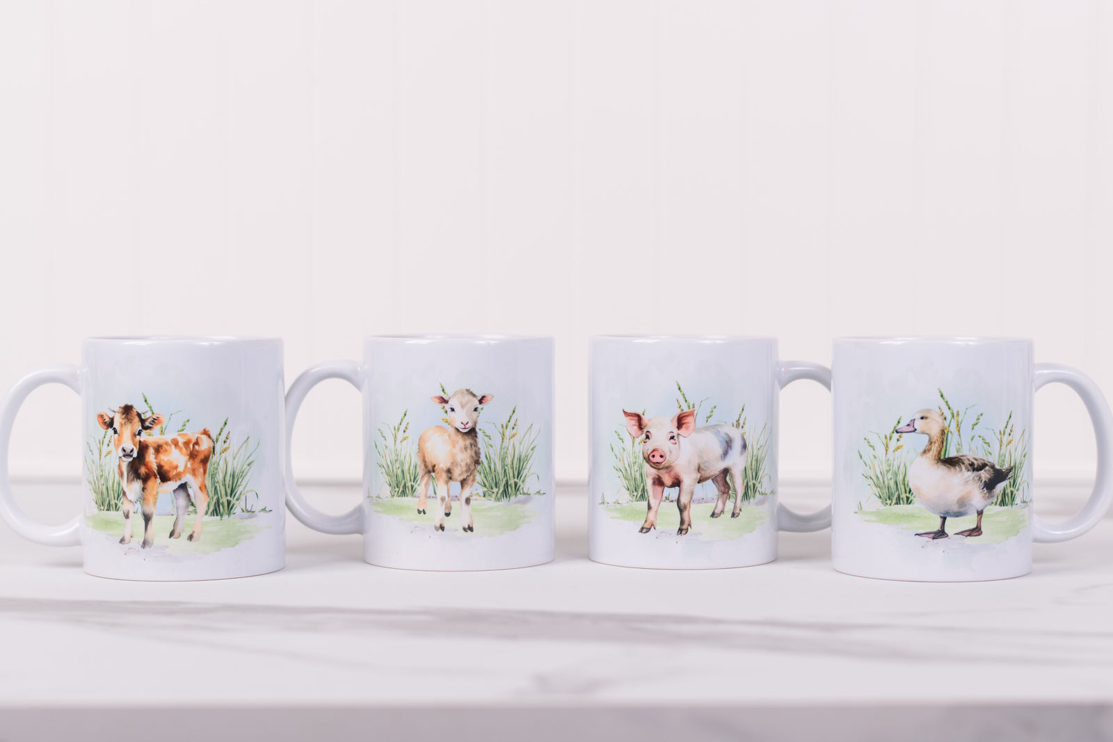 Four mugs with animal illustrations on a white surface