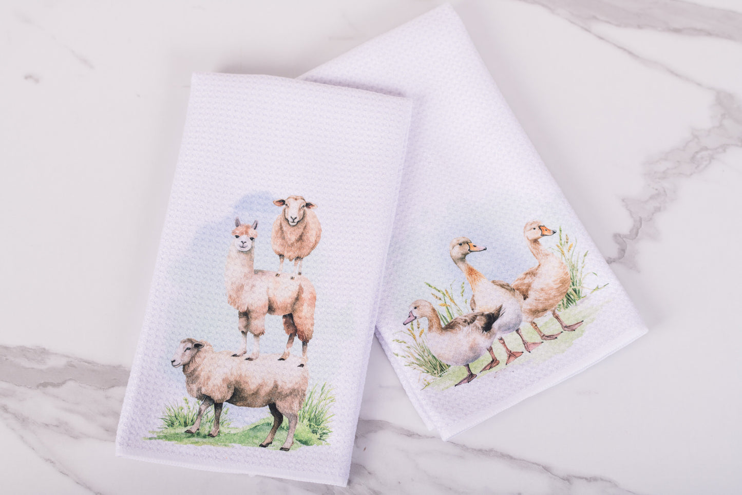 Two towels with animal prints on a marble surface