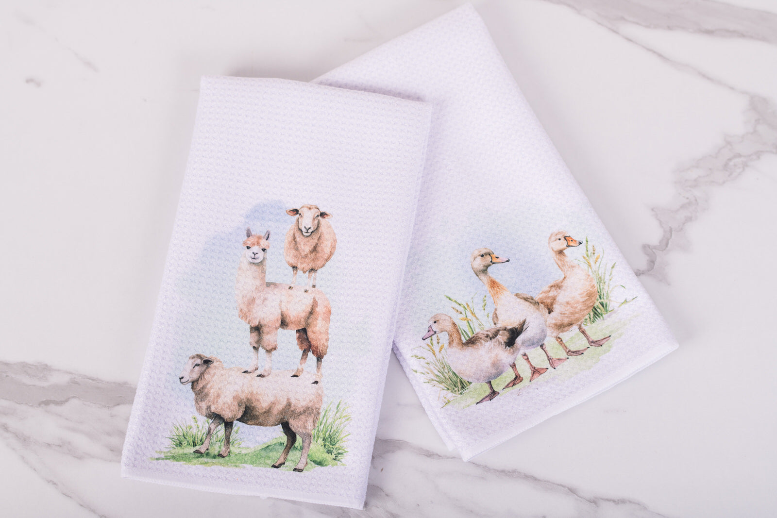 Two towels with animal prints on a marble surface