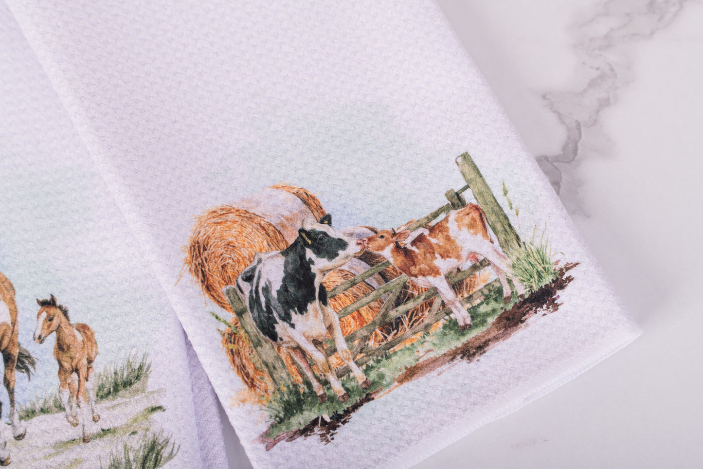 Towel with a cow and calf design on a marble surface