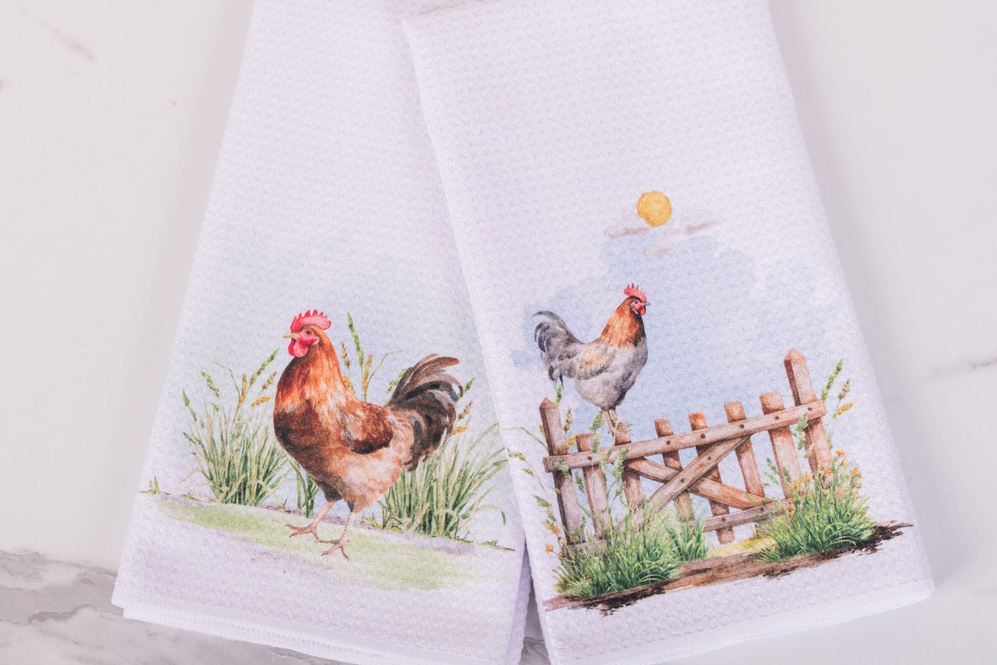 Two towels with rooster designs on a white background