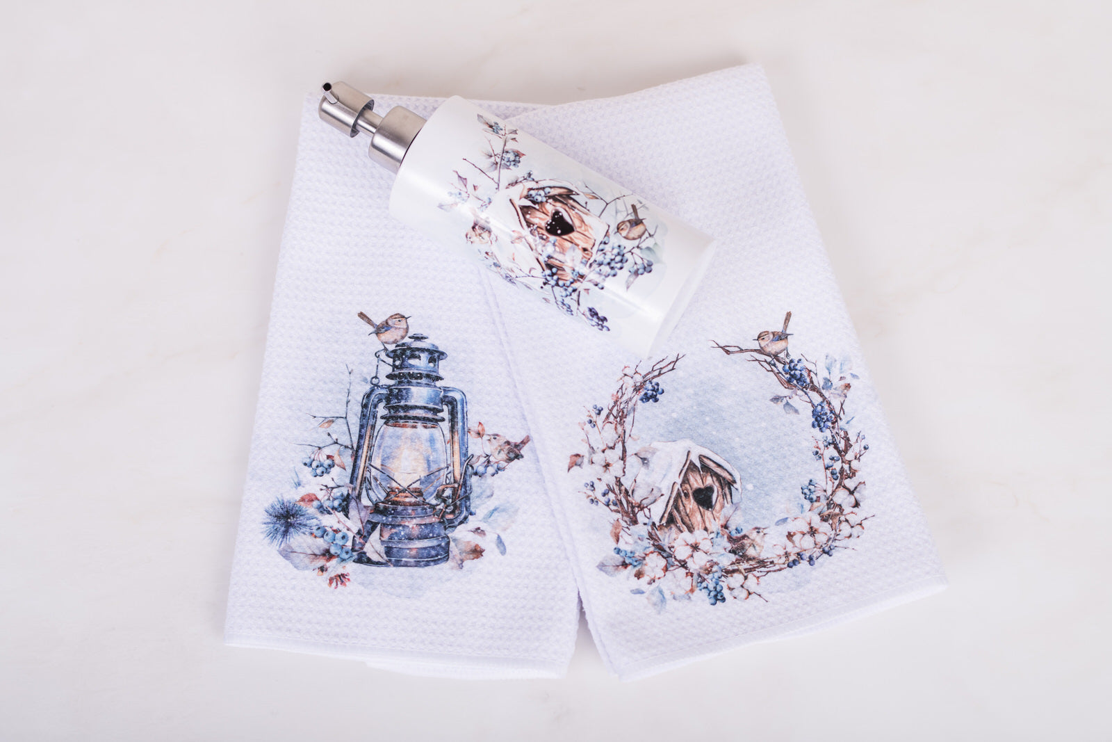 Flat lay of Let It Snow hostess gift bundle with 2 folded tea towels and white stainless soap holder