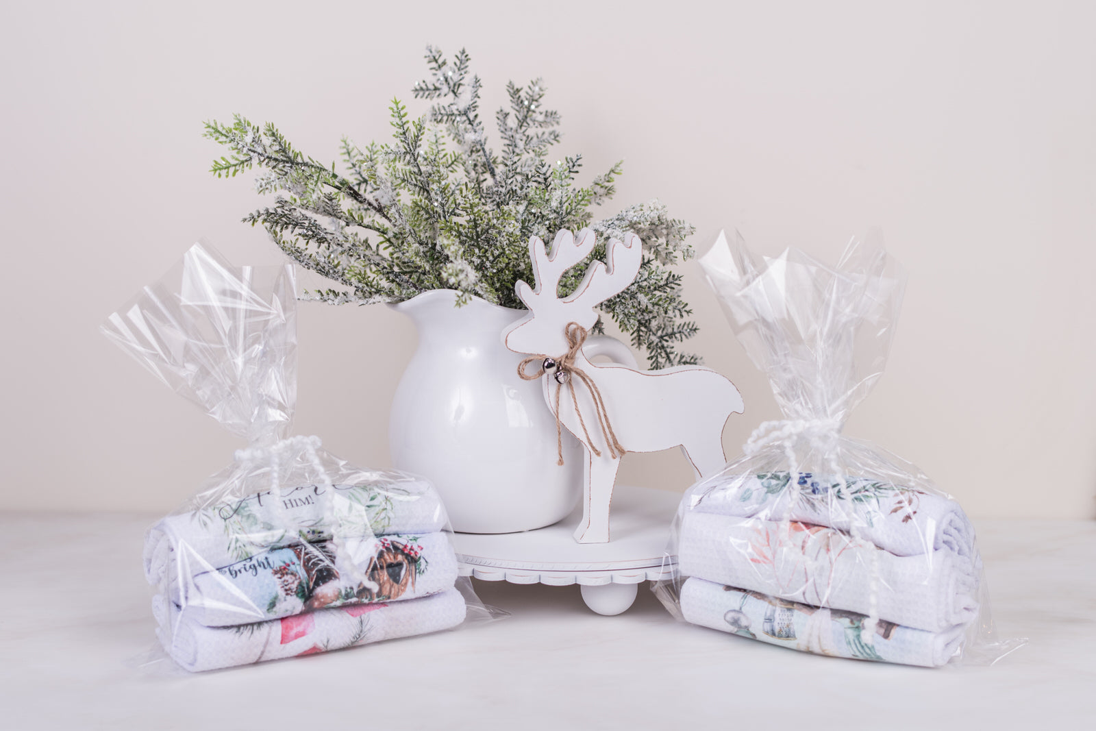 Three curated tea towels bundled with ribbon, holiday-themed