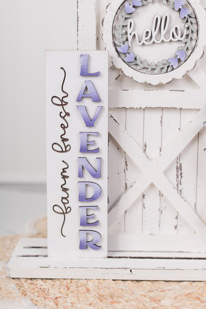 Decorative sign with 'Farm Fresh Lavender' text on a white wooden background