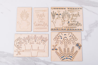 Set of wooden laser-cut decorative inserts with lavender and text designs on a light gray background.