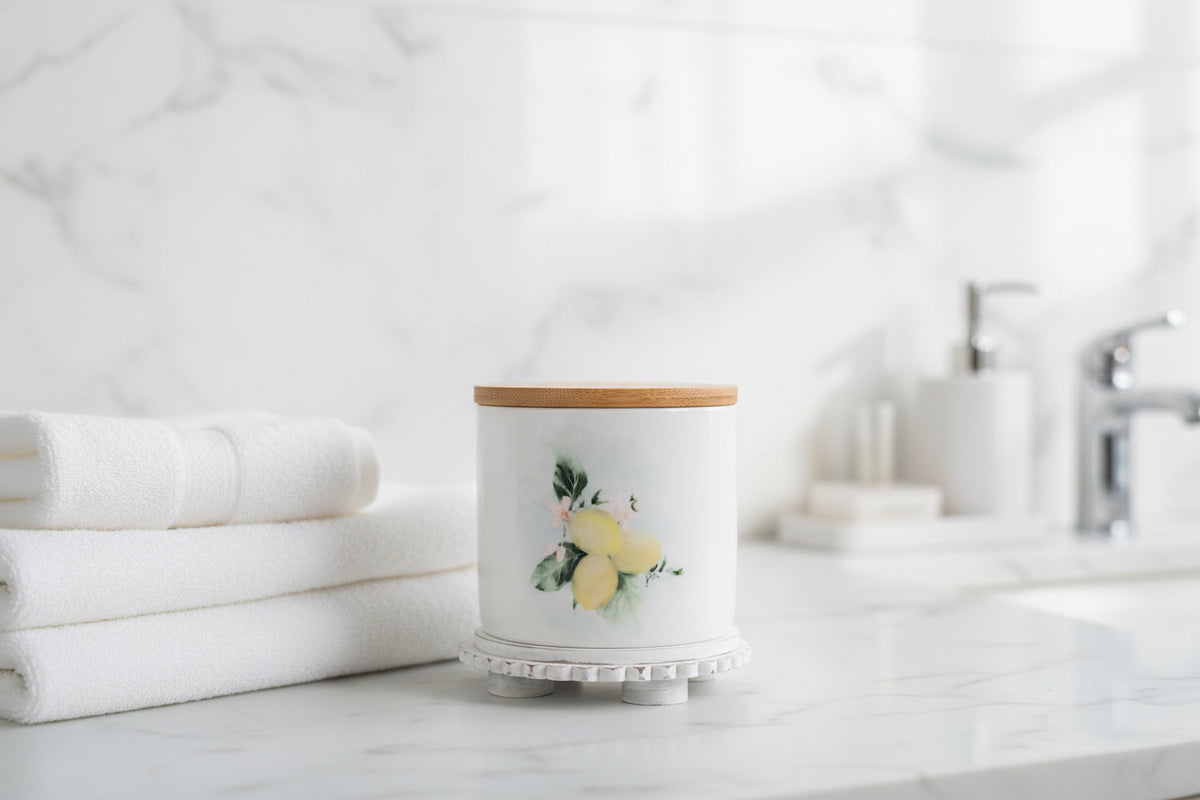 Small lemon canister, styled in bathroom on a white marble surface with white towels in the background