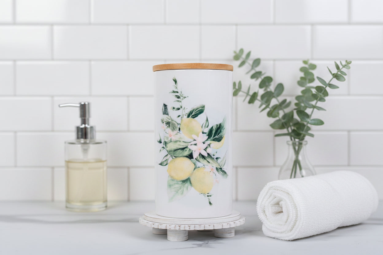 Lemon cannister in a bathroom with towels and eucalyptus with a white tiled background