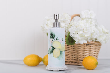 Stainless steel lemon soap, or lotion, dispenser styled with a basket of florals and lemons on a white surface