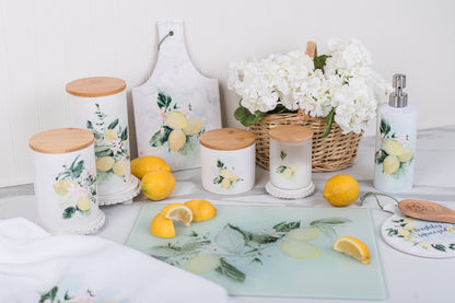 Decorative kitchen items with lemon and floral designs on a white surface.