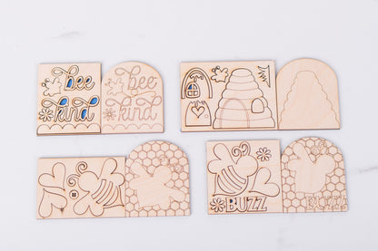 Set of wooden blanks with bee-themed designs on a white background