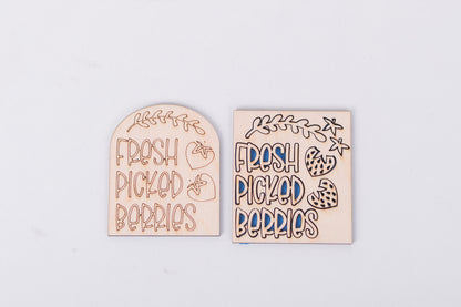Two wooden signs with 'Fresh Picked Berries' text on a light gray background