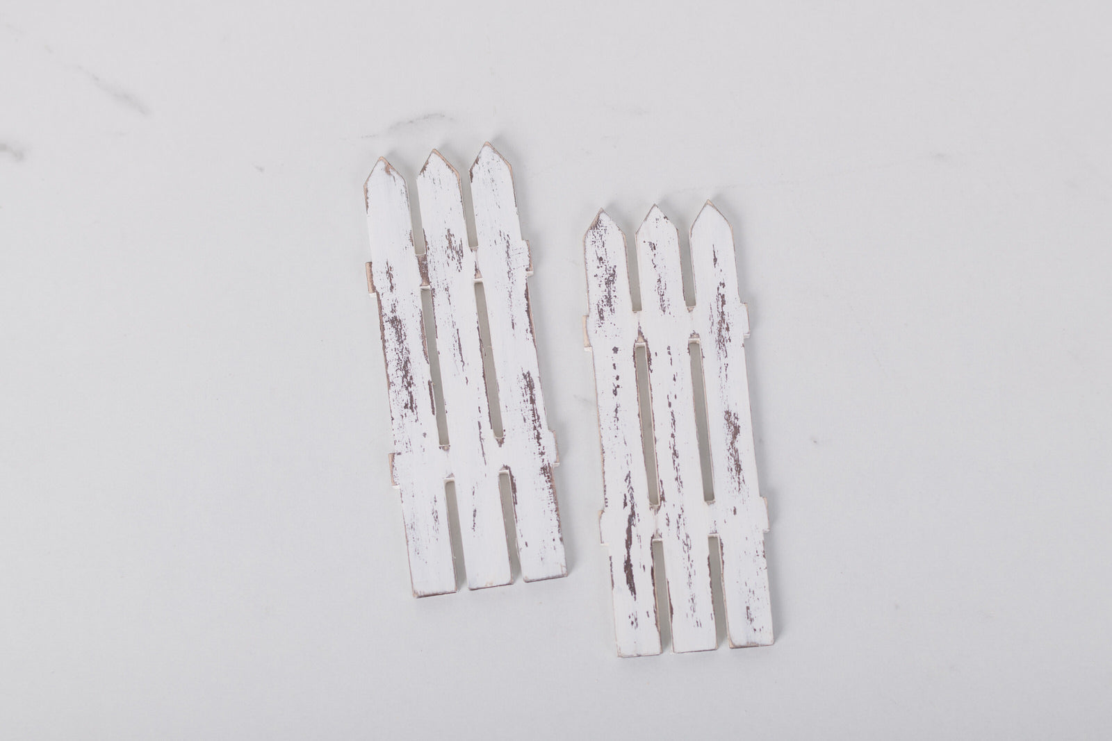 Two white picket fence decorations on a light gray background