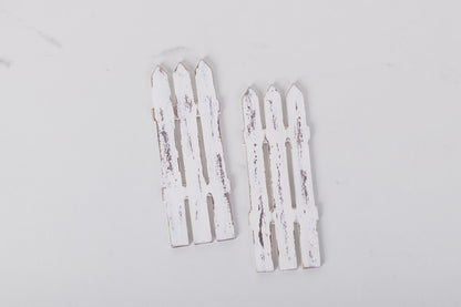 Two white picket fence decorations on a light gray background
