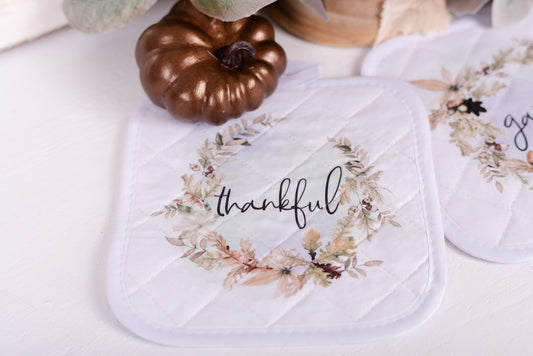 Quilted potholder with fall oak leaves and acorn wreath with the word thankful 