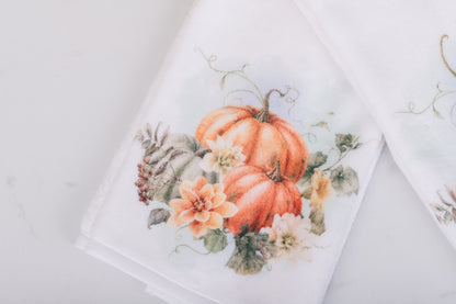 Decorative hand towel with pumpkins and floral design on a white background