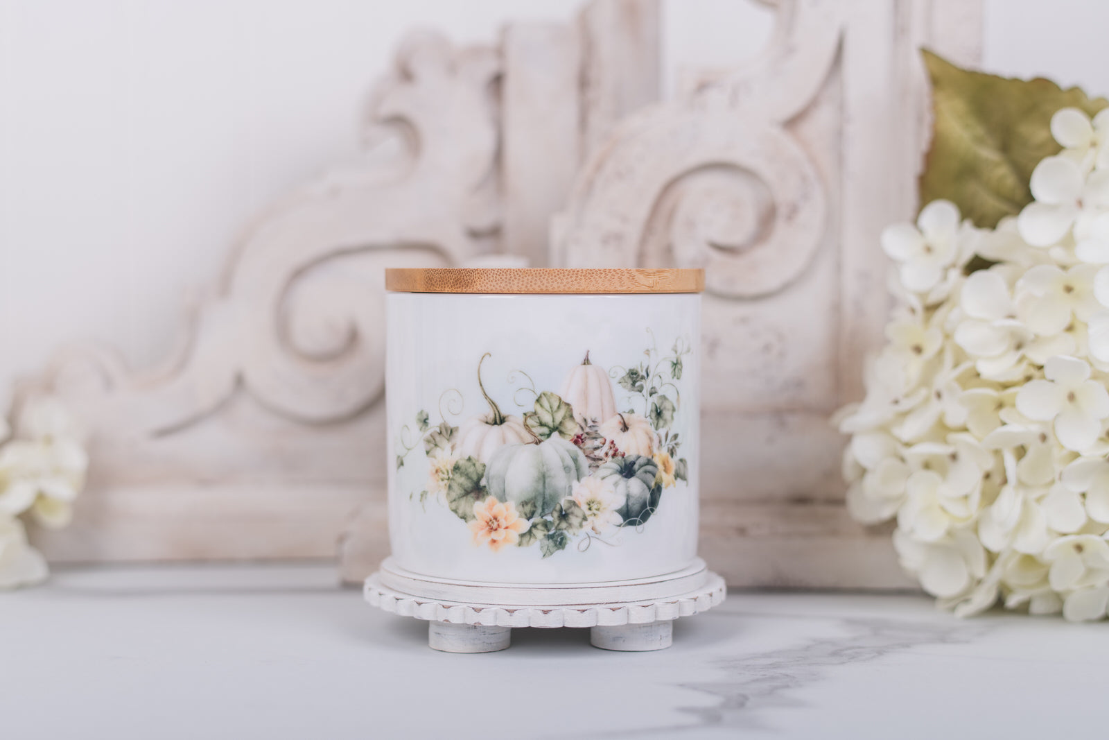 Small ceramic canister with soft white pumpkins and bamboo lid