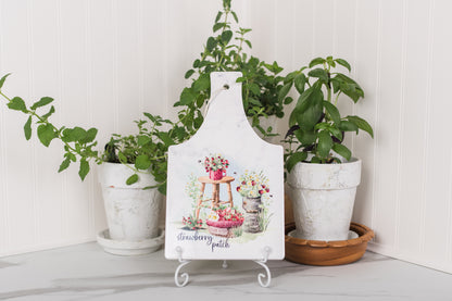 Rectangular ceramic trivet with strawberries and daisies in a cozy kitchen.