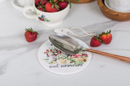 Watercolour strawberry spoon rest on a farmhouse counter.
