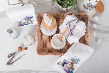 bathroom setting with hand towels, a woven tray, and decorative items on a light background.