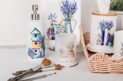 Decorative items including a candle, soap dispenser, and small plants on a white surface.