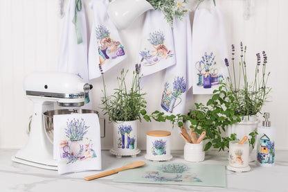 Kitchen scene with towels, plants, and kitchen items featuring lavender designs.
