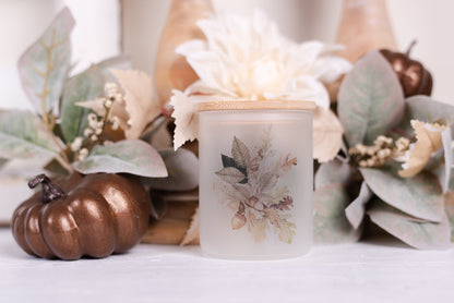 A frosted glass bathroom jar with a bamboo lid, featuring a floral design with autumn colors.