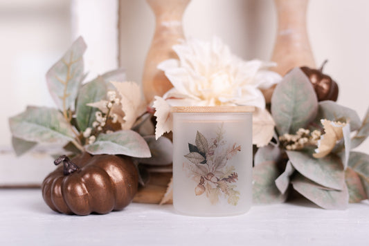 frosted glass canister styled with pumpkins and foliage