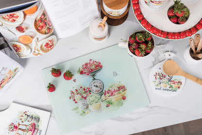 Glass strawberry cutting board styled in a cottage kitchen.