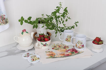 Set of four strawberry placemats on a farmhouse summer table.