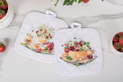 Two pot holders with floral and fruit design on a marble surface.
