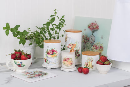 Decorative kitchen items including mugs, jars, and a plant on a white surface.