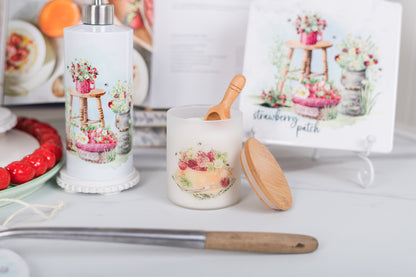 Decorative candle holder with strawberry patch design on a white surface